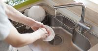 Hjemmehjaelper ordner opvasken
